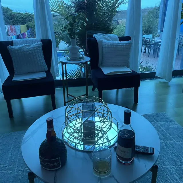 Sala de estar com mesa redonda e bebidas ao anoitecer