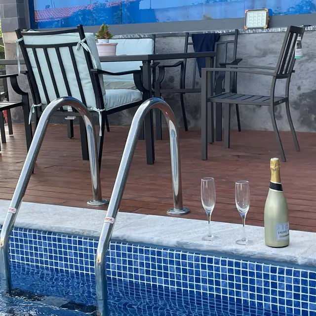 Zona de piscina com mesa e cadeiras de jantar ao anoitecer