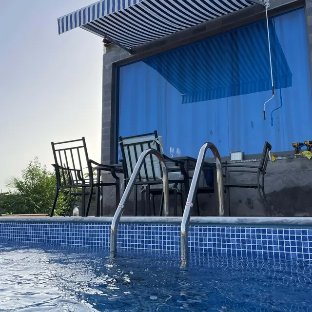 Toldo às riscas a proteger a zona de estar junto à piscina