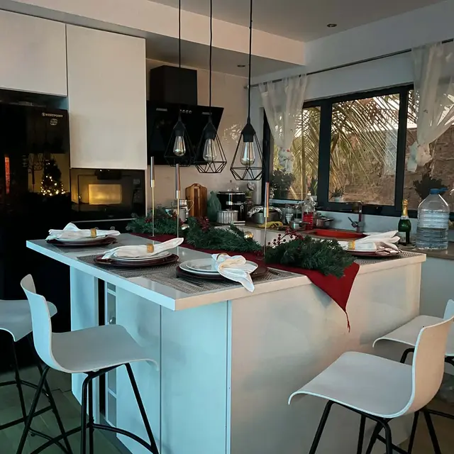 Mesa posta com toalha vermelha e velas na bancada da cozinha